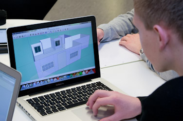 Billed af en dreng der arbejder på en computer