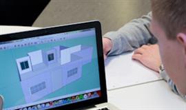 Billed af en dreng der arbejder på en computer