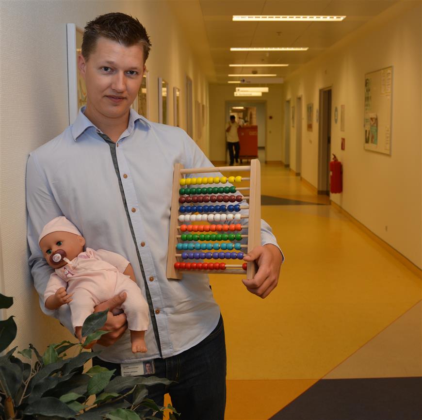 Mand holder kugleramme og dukke