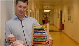 Mand holder kugleramme og dukke